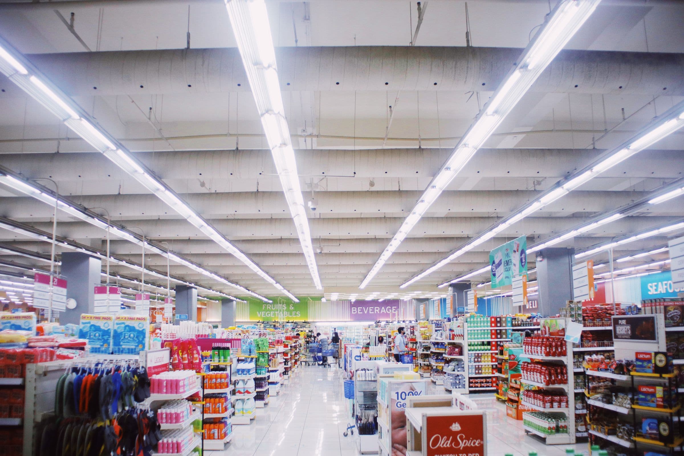 Corredor de supermercado iluminado por linhas de luz no teto