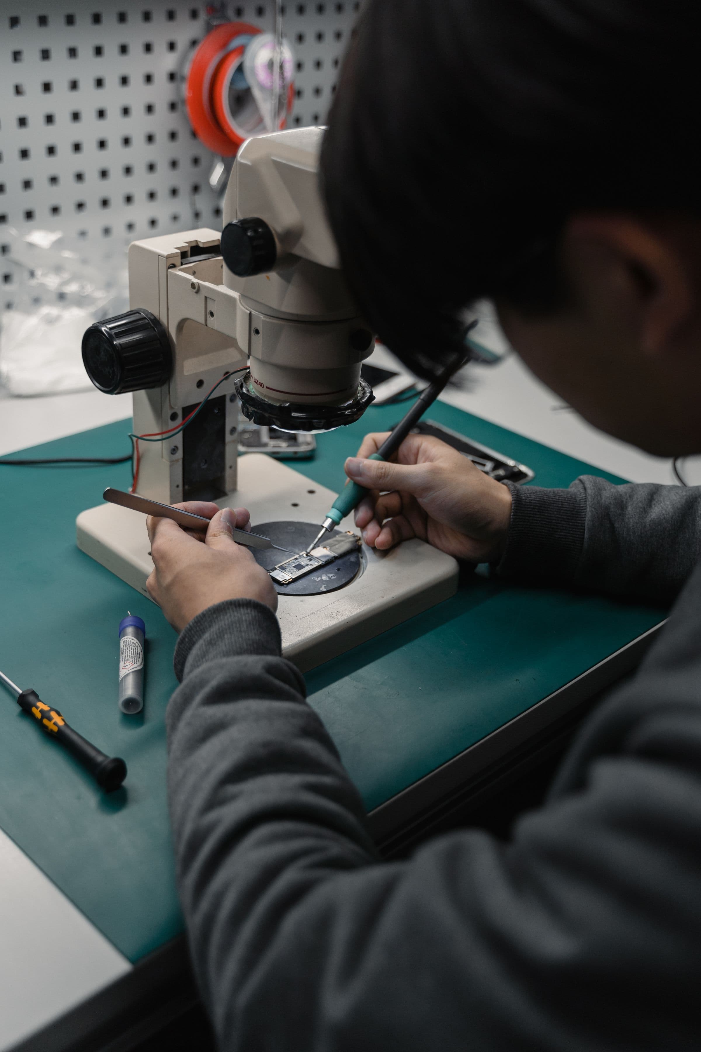 Técnico trabalhando numa bancada com microscópio